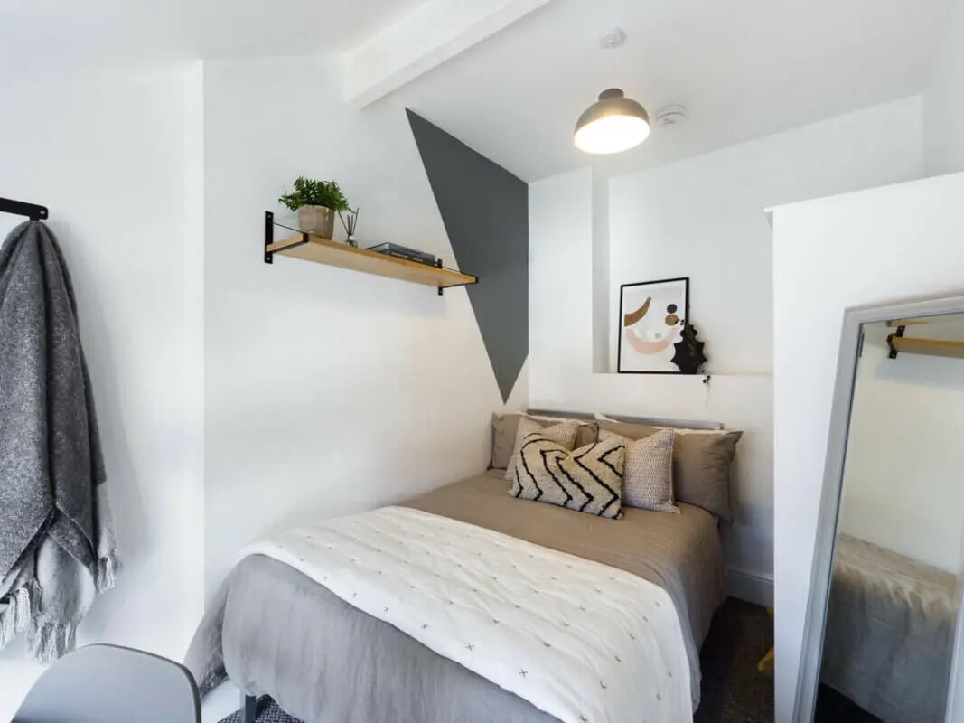 Bed with pillows artwork and shelf Bedroom at 7 Bedroom House at 3, Ruskin Avenue in Manchester Student Accommodation