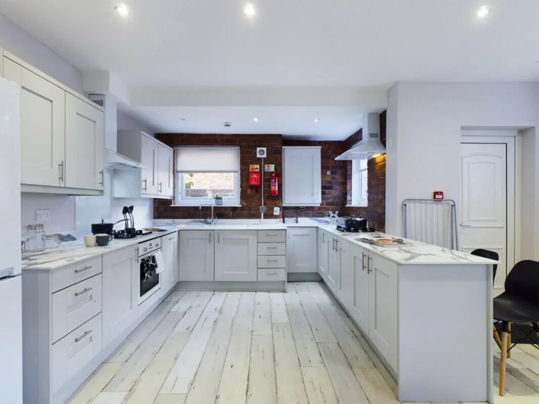 White cabinets marble countertops stove and sink kitchen at 8 Bedroom House at 211, Molyneux Road in Liverpool Student Accommodation