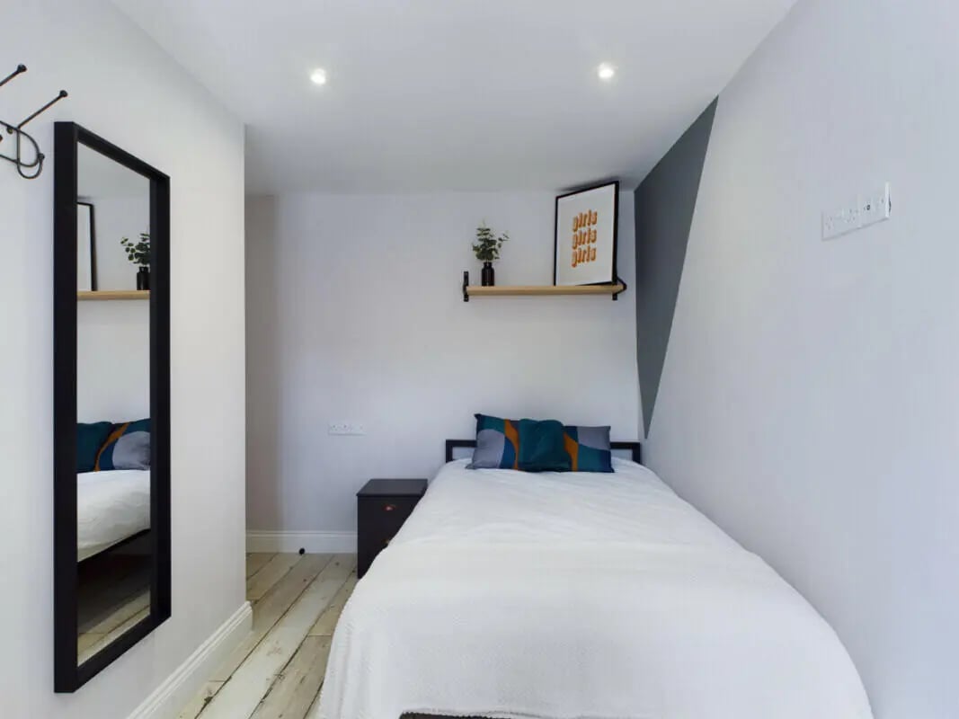 Bed with pillows and a dark nightstand bedroom at 8 Bedroom House at 211, Molyneux Road in Liverpool Student Accommodation