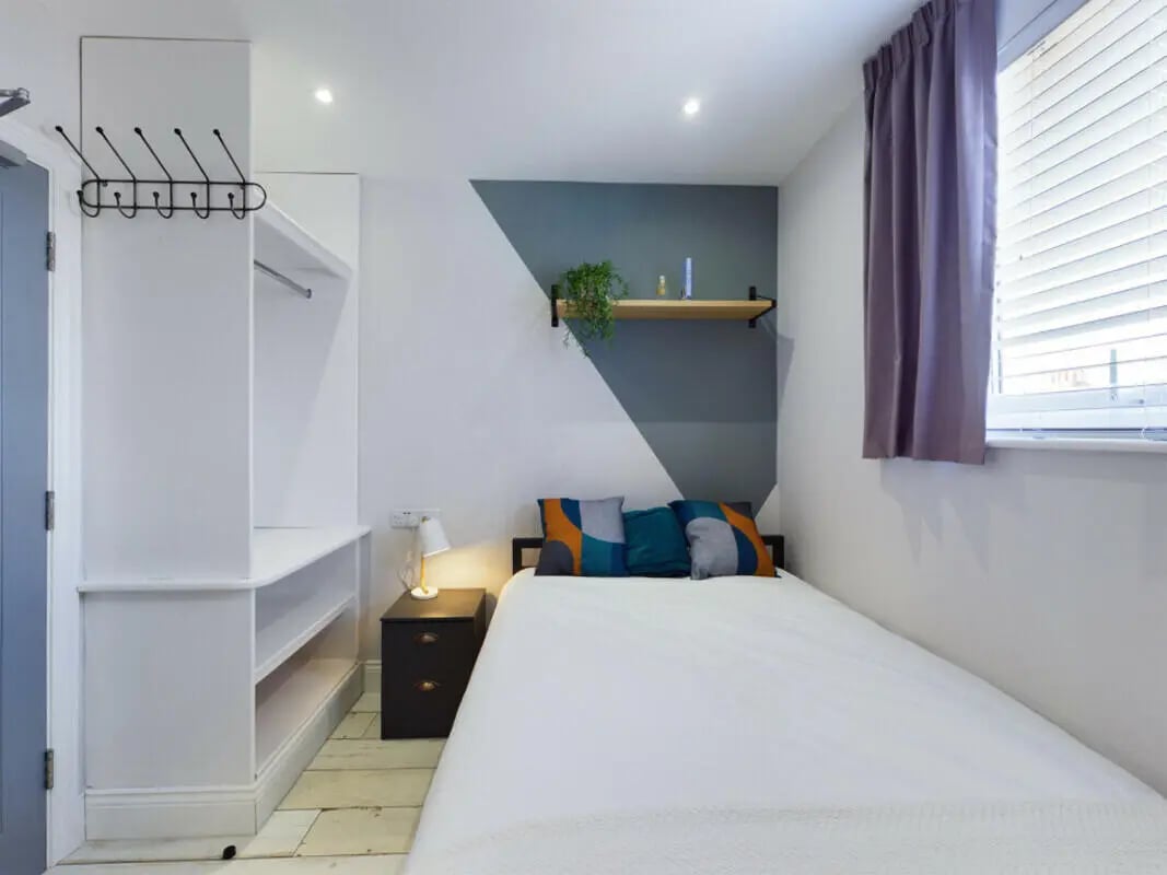 Bed with pillows nightstand and closet Bedroom at 8 Bedroom House at 211, Molyneux Road in Liverpool Student Accommodation