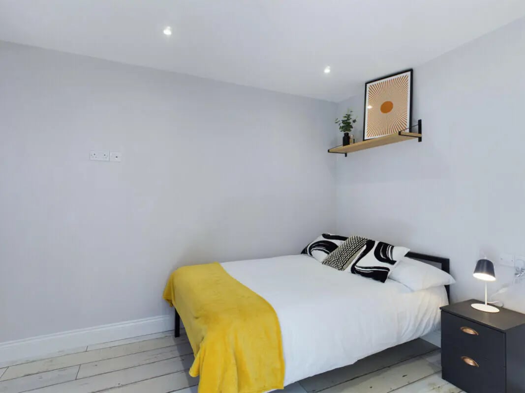 Bed with yellow throw black nightstand Bedroom at 8 Bedroom House at 211, Molyneux Road in Liverpool Student Accommodation