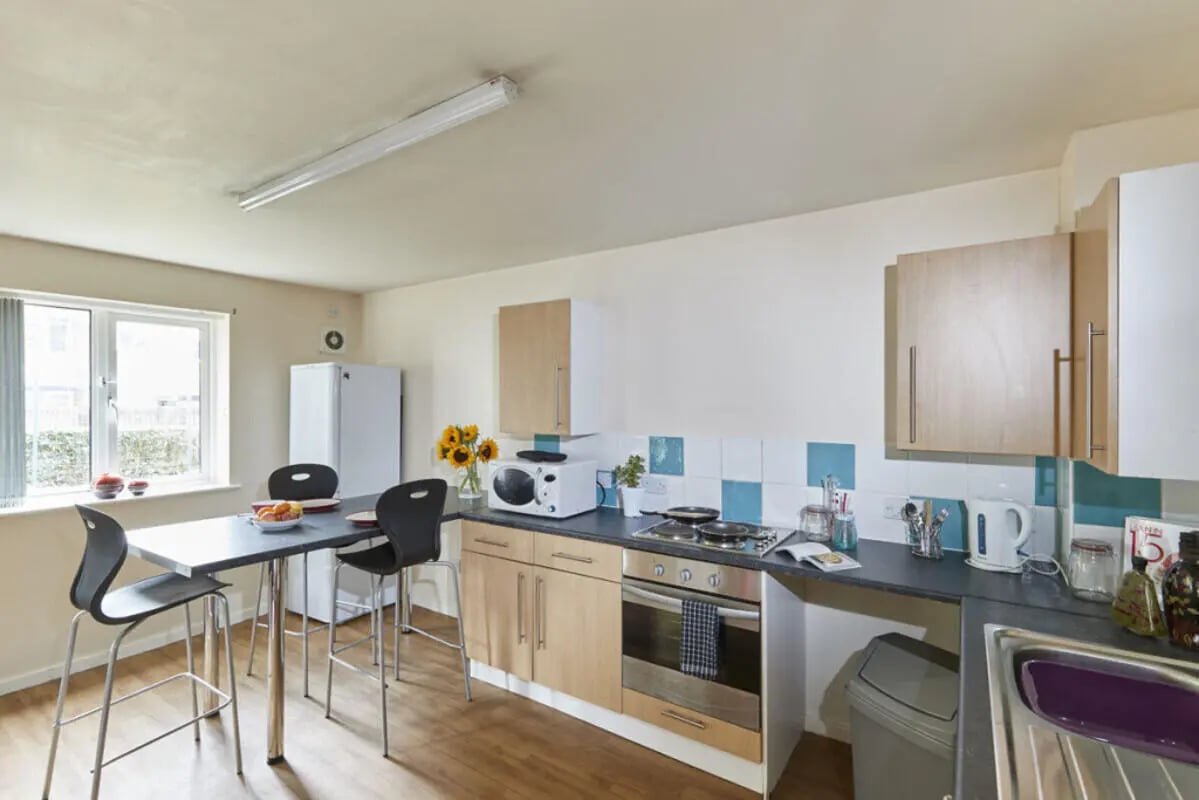 Table chairs fridge microwave oven and sink kitchen at 4 Bedroom House at 15, Brookside in Derby Student Accommodation
