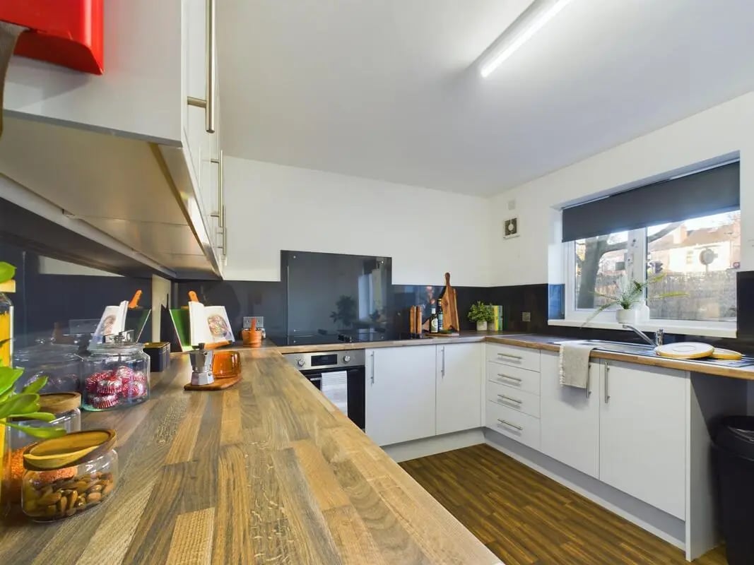 Modern kitchen with white cabinets and wooden counters kitchen at 6 Bedroom House at 24, Brookside in Derby Student Accommodation