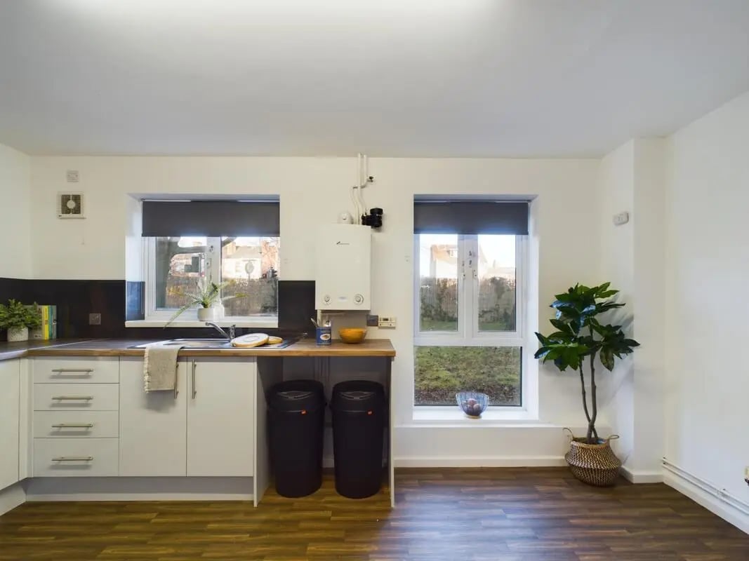 Sink cabinets trash cans and a plant kitchen at 6 Bedroom House at 27, Brookside in Derby Student Accommodation