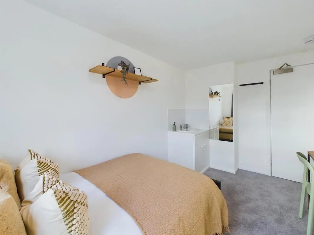 Bed sink and mirror in studio apartment at 6 Bedroom House at 1, Mint Road in Leicester Student Accommodation