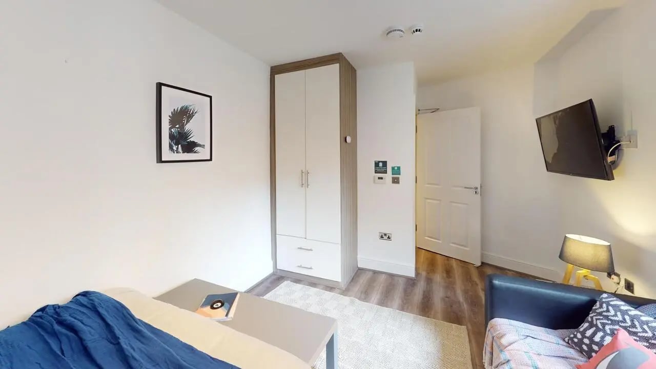 Bed with blue blanket wardrobe and TV bedroom at 1 Bedroom House at Flat 3, 265, Edge Lane in Liverpool Student Accommodation
