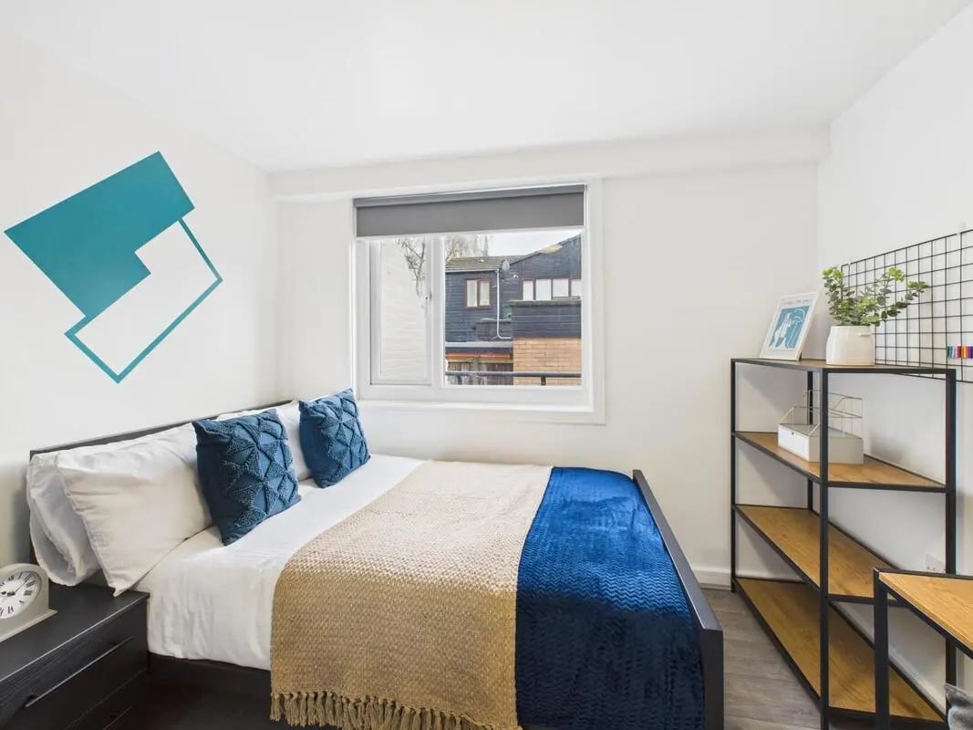 Bed with blue pillows and blankets, shelves bedroom at 2 Bedroom House at Flat 1, Grove Street Studios, The Groves in Liverpool Student Accommodation