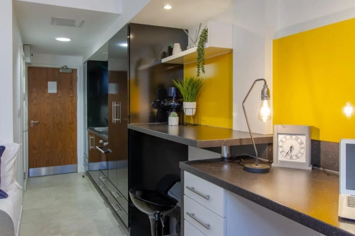 Modern kitchen area with yellow accent wall at Bowman House in Nottingham Student Accommodation