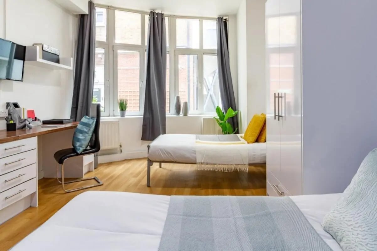 Two beds desk chair and wardrobe bedroom at Portobello Garrow House in London Student Accommodation