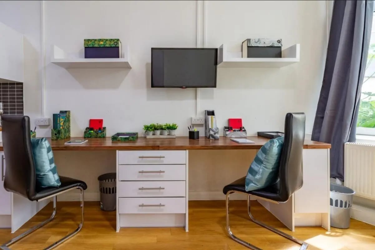 Desk with chairs and storage study area at Portobello Garrow House in London Student Accommodation