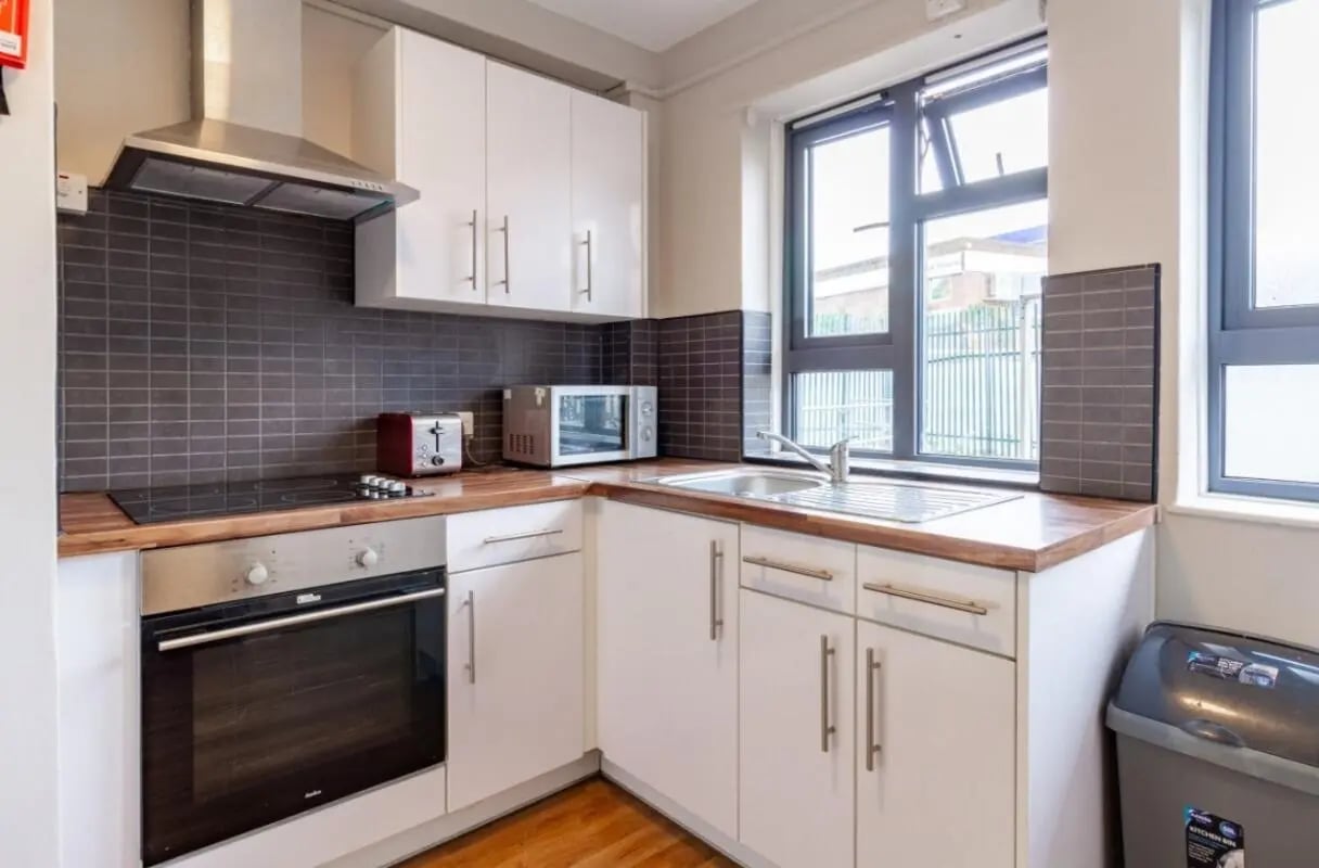 White cabinets oven sink toaster microwave kitchen at Surrey Quays Landale House in London Student Accommodation