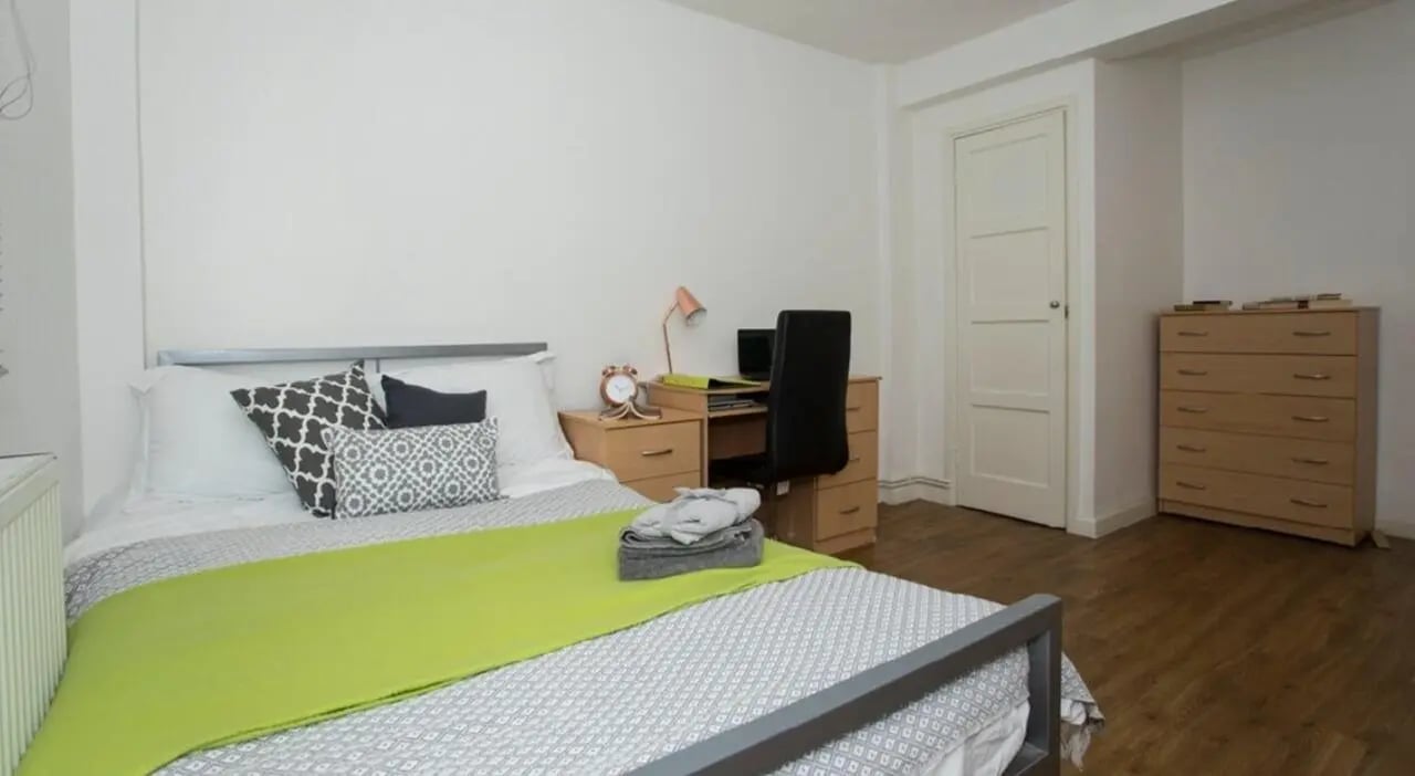 Bed desk chair dresser and pillows bedroom at Surrey Quays Landale House in London Student Accommodation