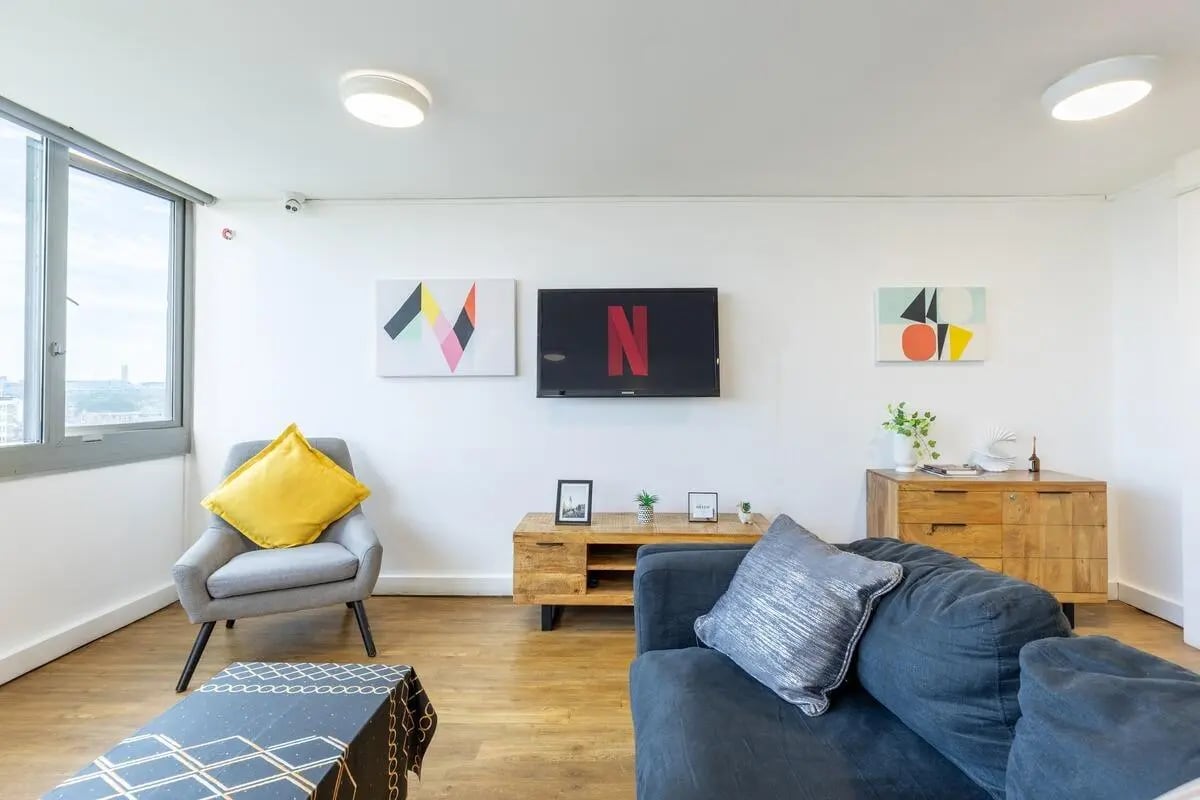 Sofa armchair TV art wooden dresser living room at Chelsea Lightfoot Hall in London Student Accommodation