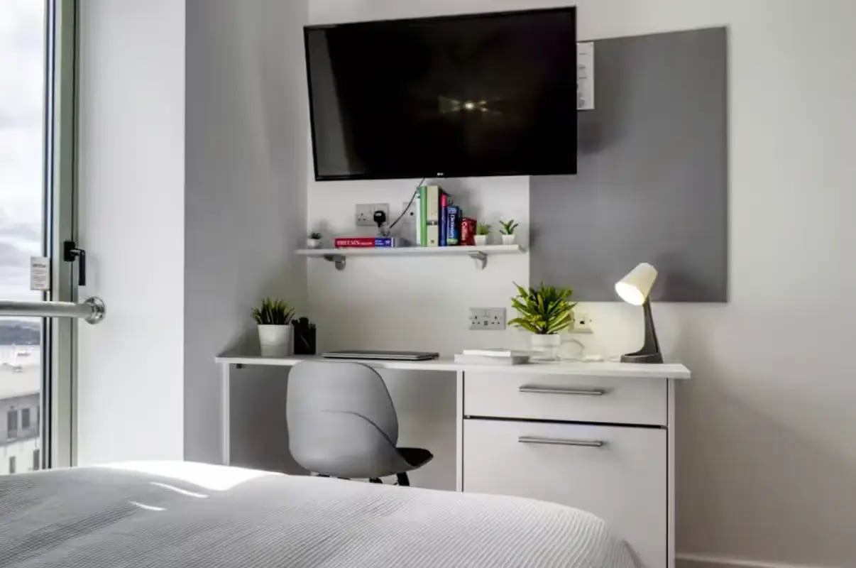 Desk lamp books TV and chair bedroom study area at Orbital in Nottingham Student Accommodation