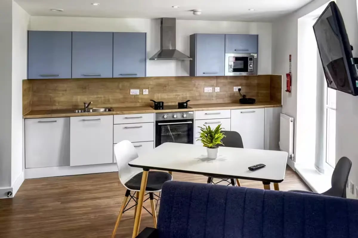 Modern kitchen with blue cabinets microwave oven table kitchen at Orbital in Nottingham Student Accommodation