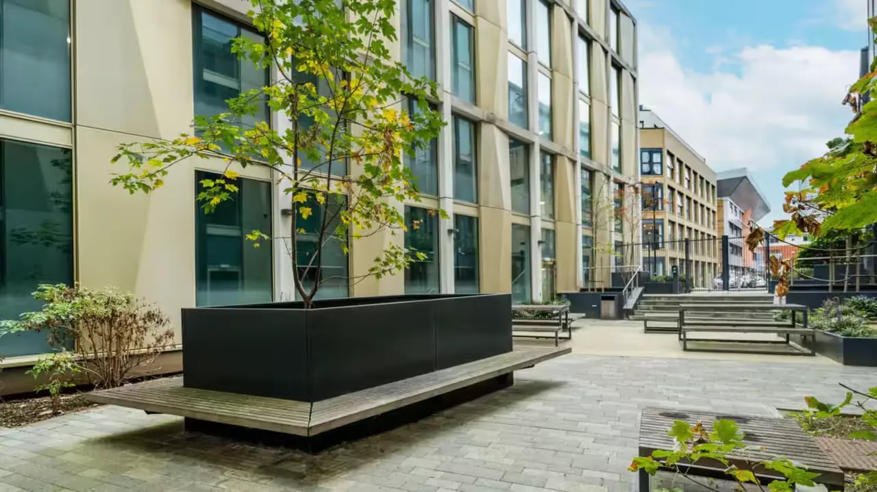 Courtyard with benches planter and modern building exterior at Flora Building - Hoxton in London Student Accommodation