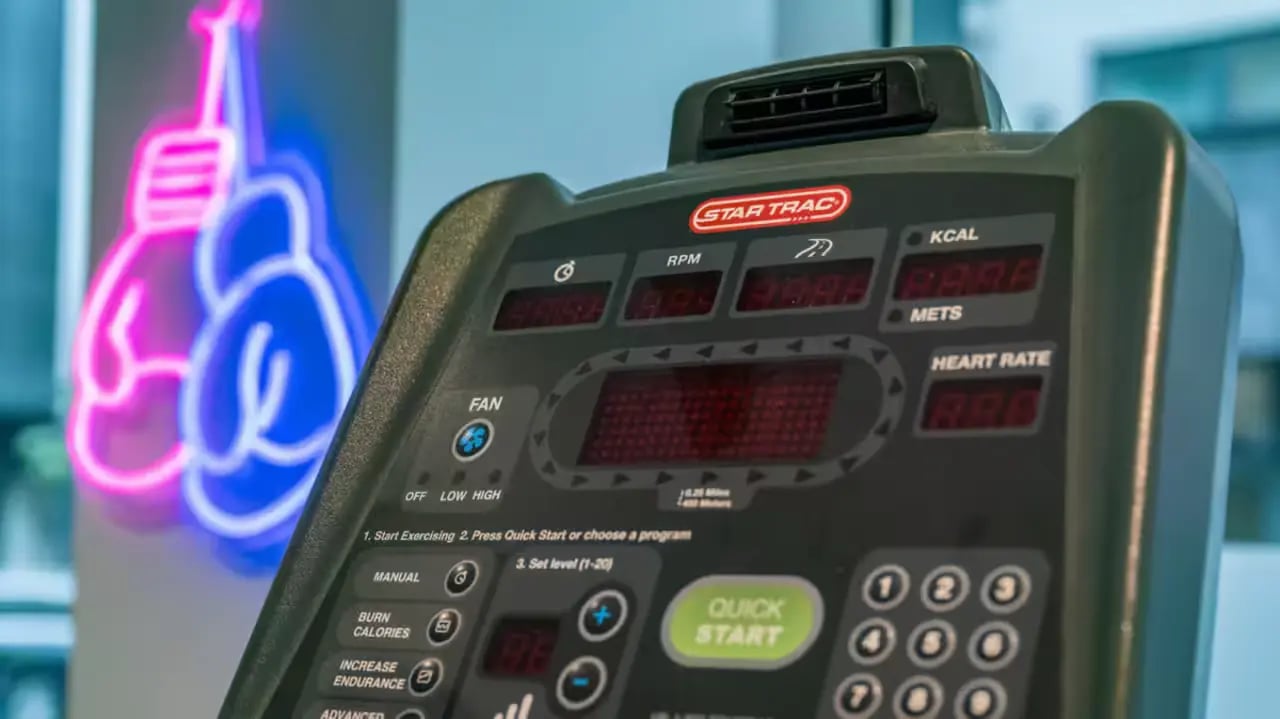 Treadmill console boxing gloves neon sign fitness room at Flora Building - Hoxton in London Student Accommodation