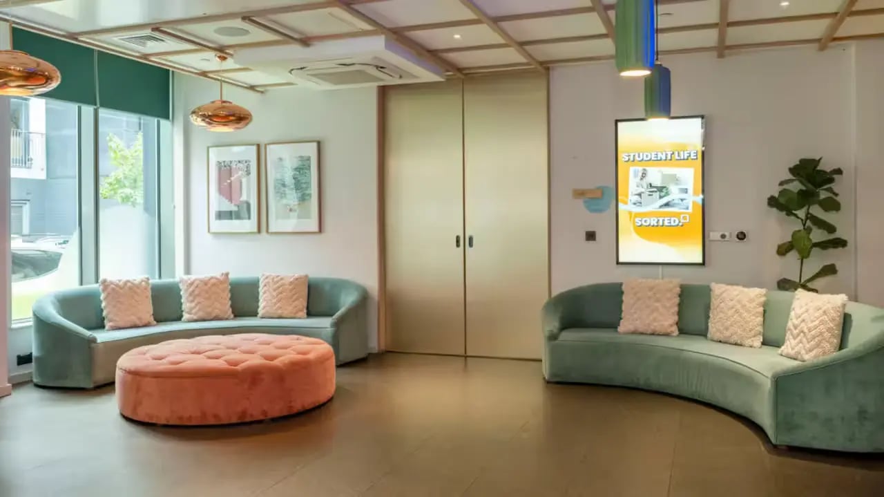 Modern lounge with sofas and ottoman living room at Flora Building - Hoxton in London Student Accommodation