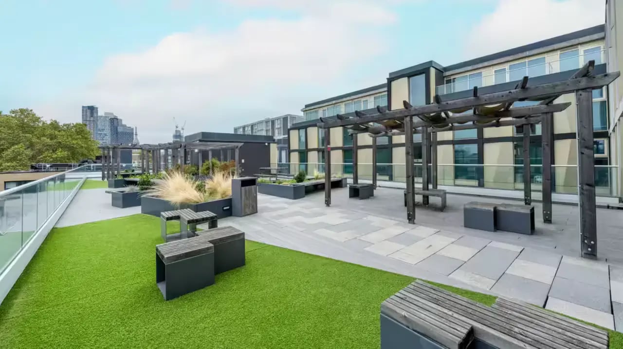 Pergolas benches planters and grass area exterior at Flora Building - Hoxton in London Student Accommodation