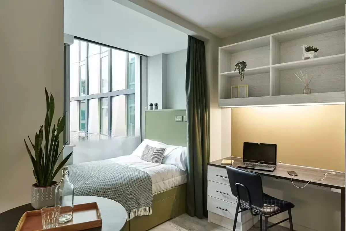 Bed desk and shelving with laptop bedroom study area at Flora Building - Hoxton in London Student Accommodation