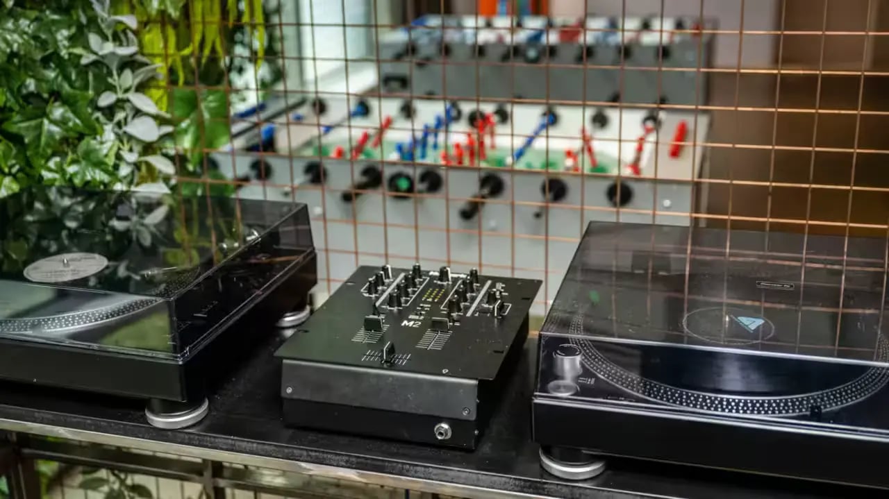 Turntables and mixer behind foosball table playing area at Flora Building - Hoxton in London Student Accommodation