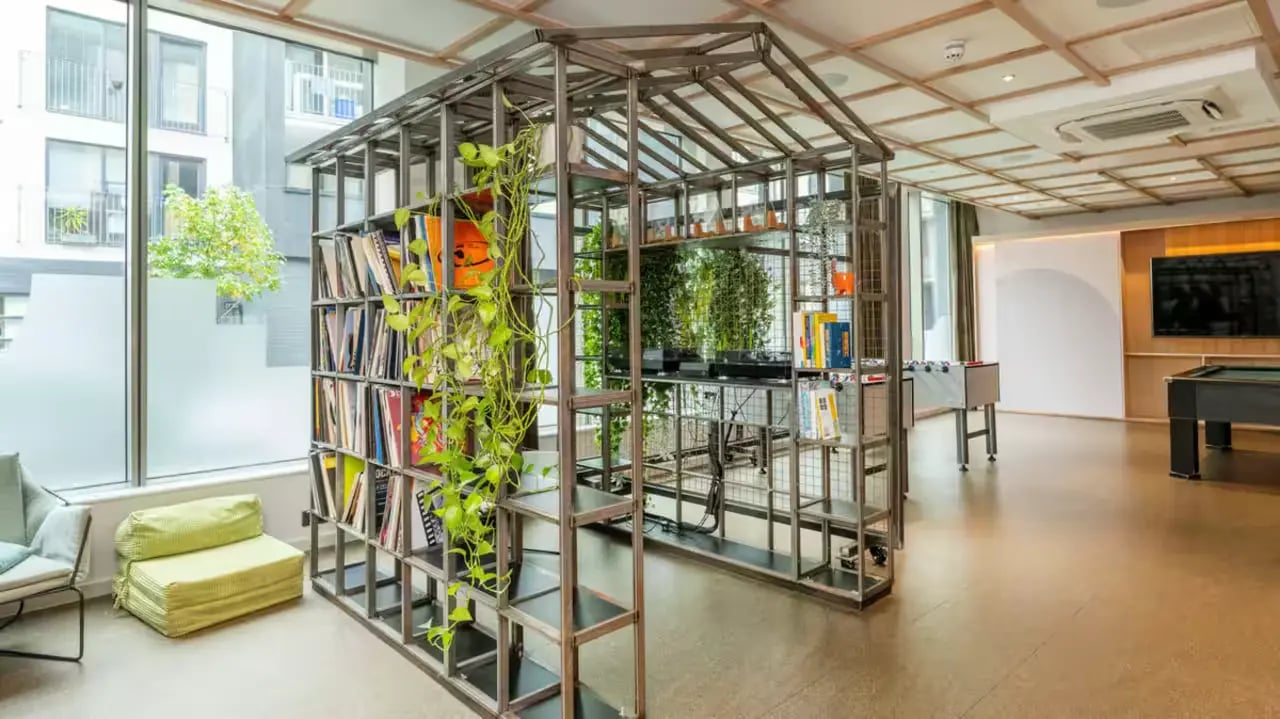 Books plants foosball and pool common area at Flora Building - Hoxton in London Student Accommodation
