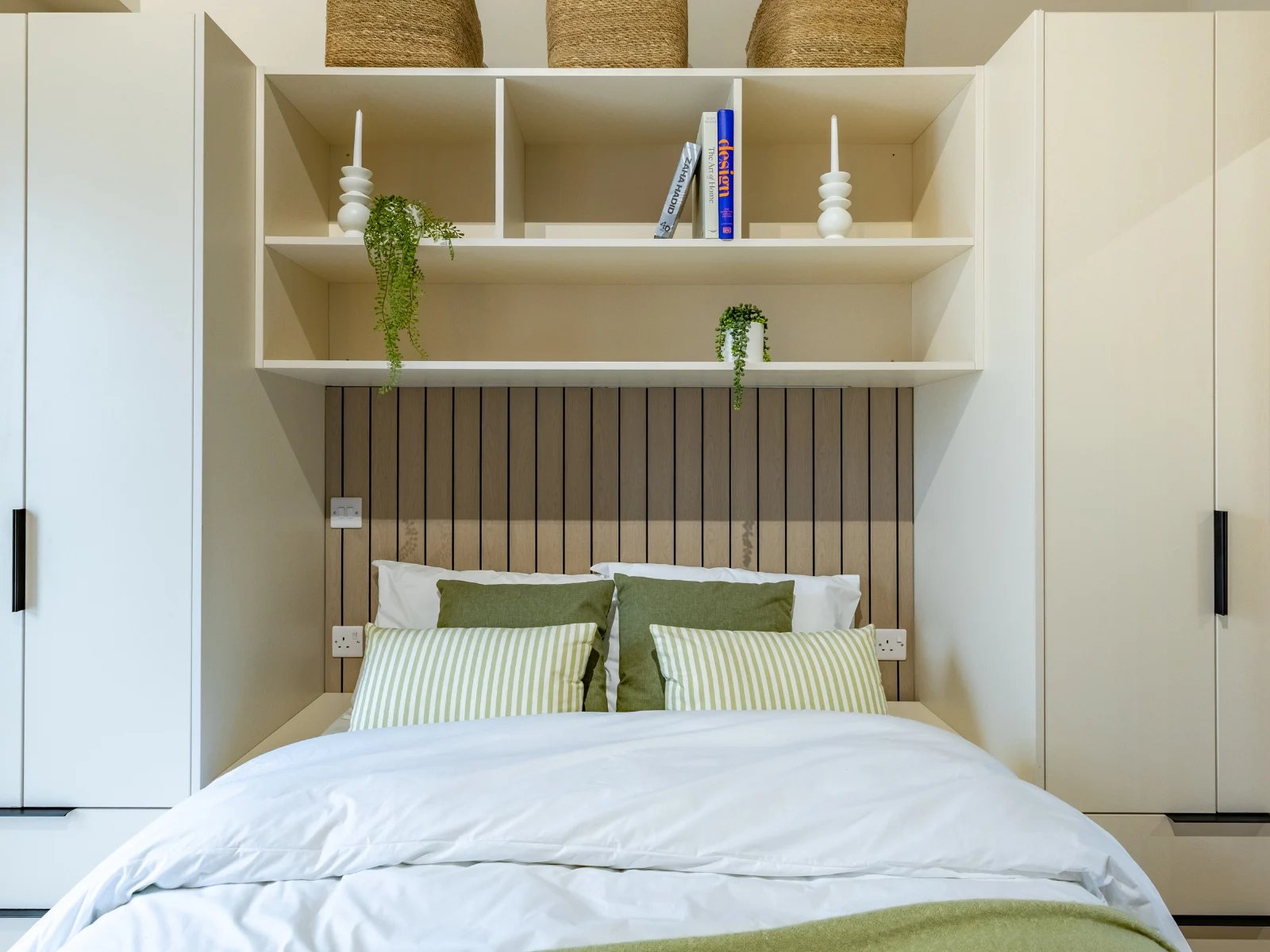 Bed with green striped pillows shelving and storage bedroom at Fitz and Knox in Cardiff Student Accommodation