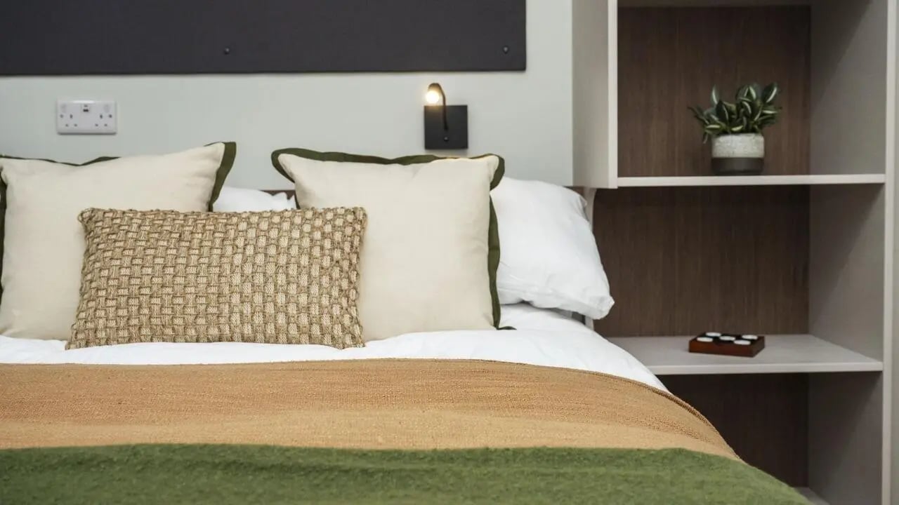 Bed with pillows blanket shelf bedroom at Broadway Studios in Glasgow Student Accommodation