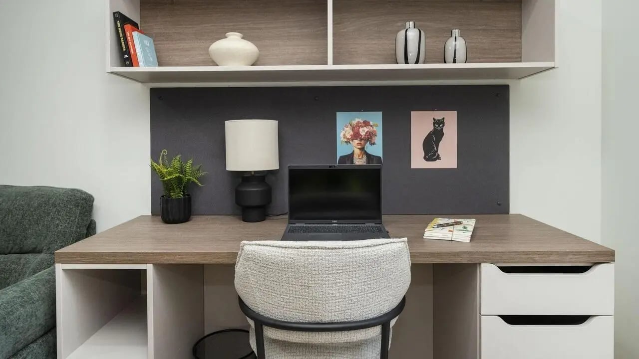 Desk with laptop lamp plant and artworks Study area at Broadway Studios in Glasgow Student Accommodation