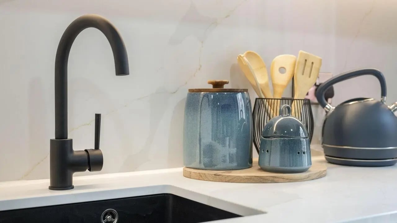Black faucet blue jars wooden utensils kettle kitchen at Broadway Studios in Glasgow Student Accommodation