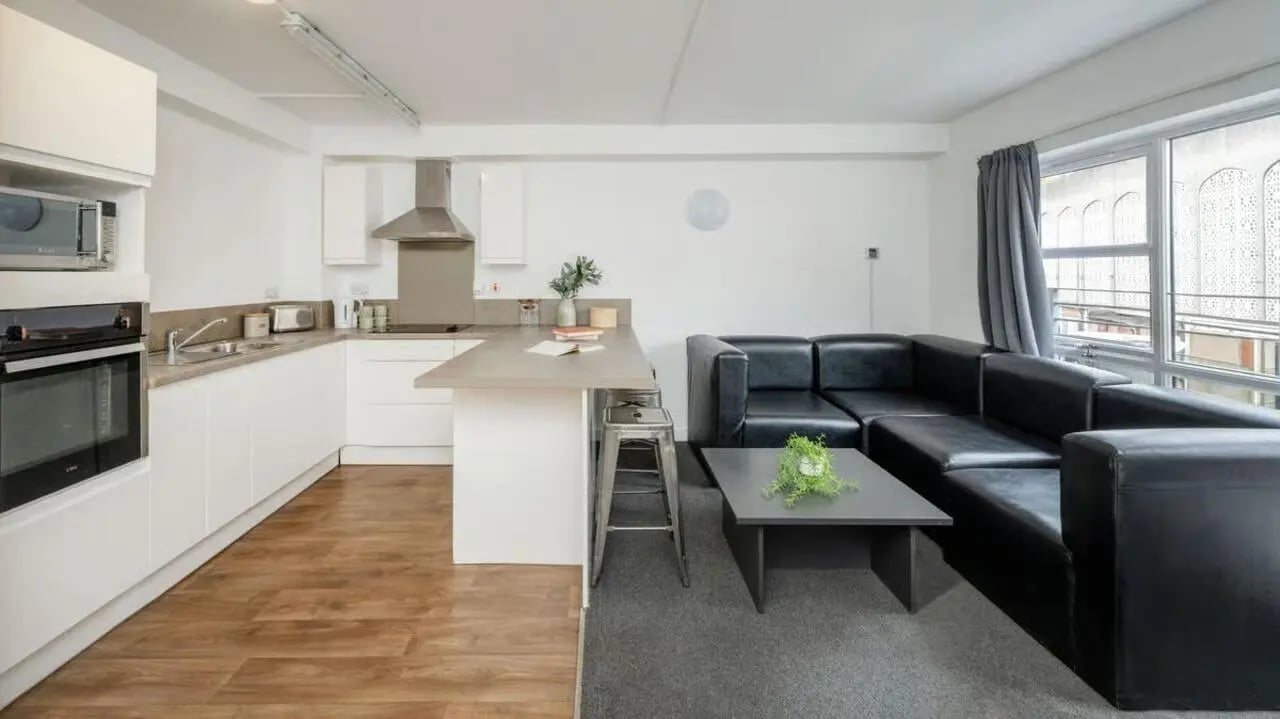 Kitchen with black leather sectional sofa living room at Curzon House in Nottingham Student Accommodation