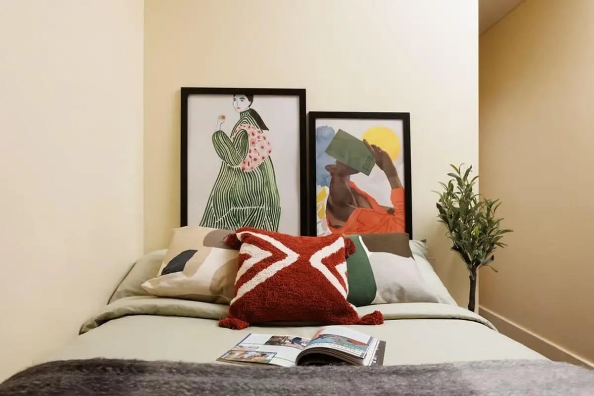 Bed with framed art pillows and plant Bedroom at Curzon House in Nottingham Student Accommodation