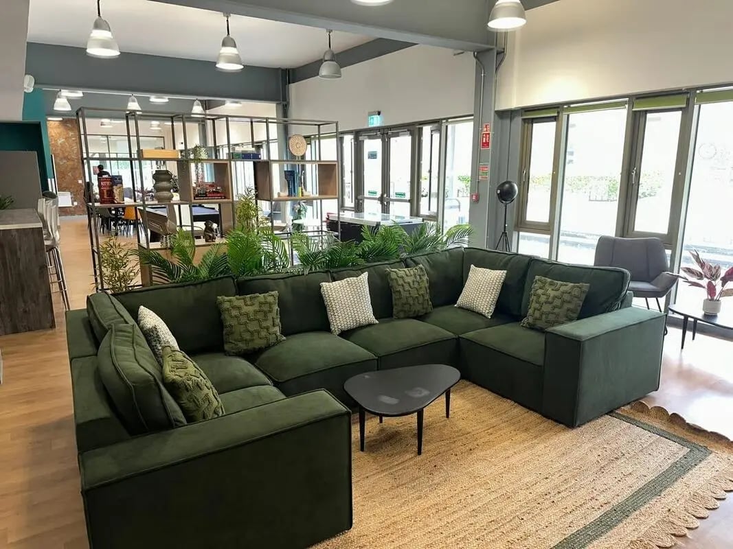 Large green sectional sofa with plants living room at Foundry Courtyard in Glasgow Student Accommodation