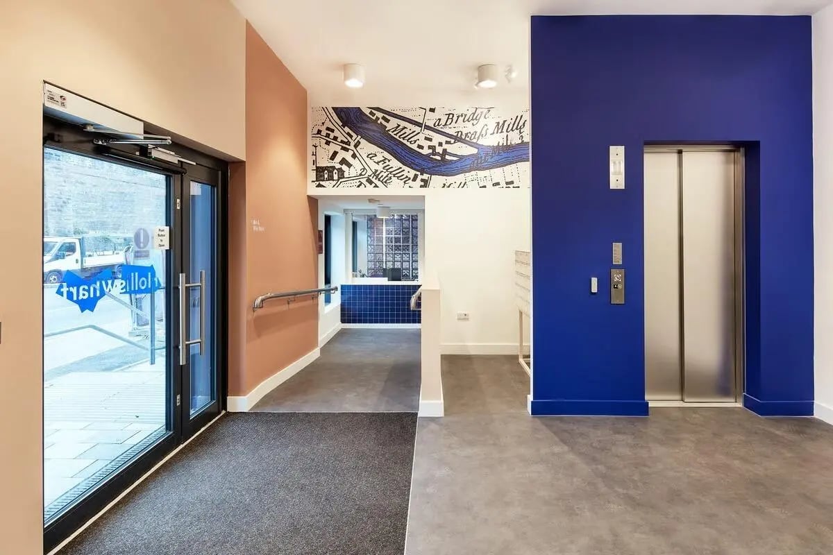 Entrance lobby with glass doors elevator and map artwork lobby at Hollis Wharf in Bath Student Accommodation