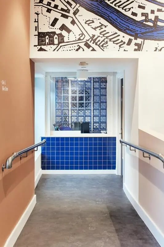 Reception desk with blue tiles and glass block window. at Hollis Wharf in Bath Student Accommodation
