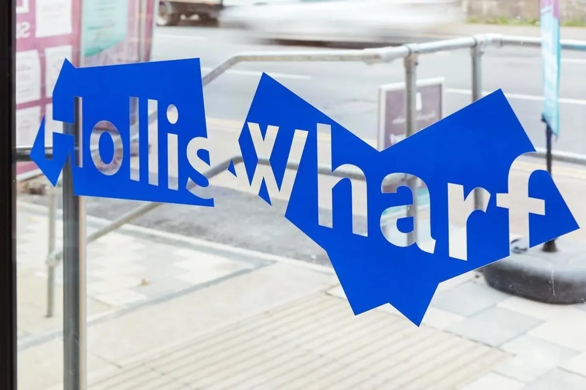 Blue logo spelling Hollis Wharf exterior signage at Hollis Wharf in Bath Student Accommodation