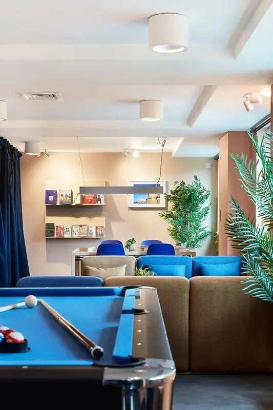 Pool table sofas blue chairs plant living area at Hollis Wharf in Bath Student Accommodation