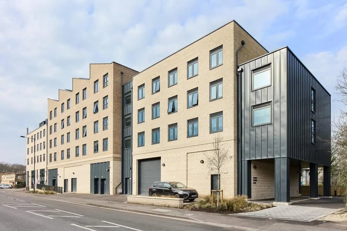 Modern multi-story building with car parked exterior at Hollis Wharf in Bath Student Accommodation