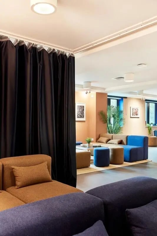 Sofa seating, ottomans, plant and artwork lounge at Hollis Wharf in Bath Student Accommodation
