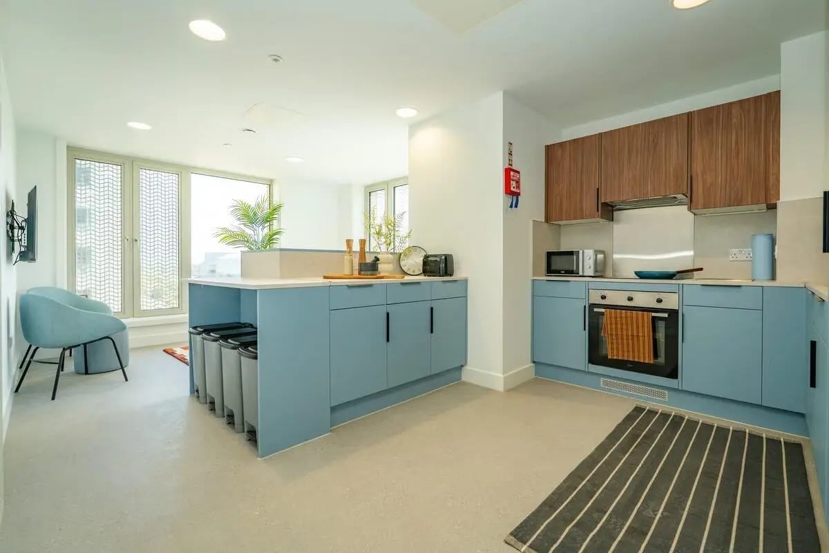 Blue cabinets oven microwave kitchen island kitchen at The Propeller Quarter in Bristol Student Accommodation
