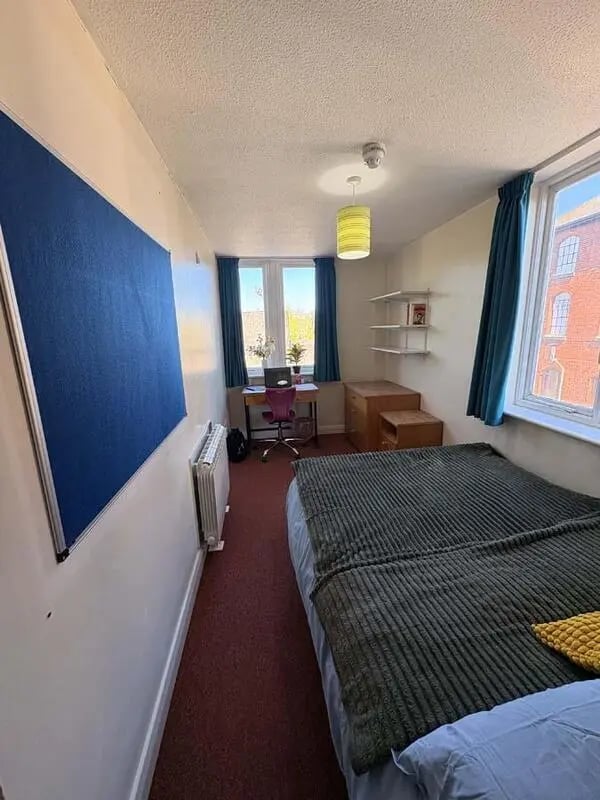 Bed desk radiator blue bulletin board bedroom at Pin Hill in Canterbury Student Accommodation