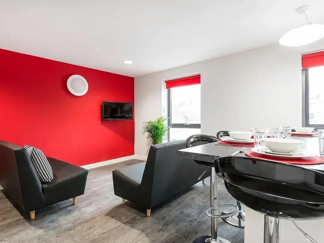 Black sofas television and dining area Living room at Yugo Arofan House in Cardiff Student Accommodation