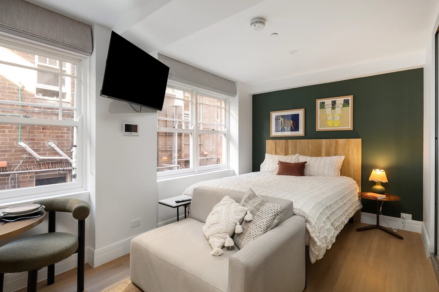 Bed couch tv paintings and lamp bedroom at UKO Potts Point in Sydney Student Accommodation