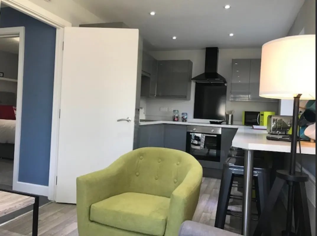 Green armchair and kitchen counter kitchen at Varsity Beeston in Nottingham Student Accommodation