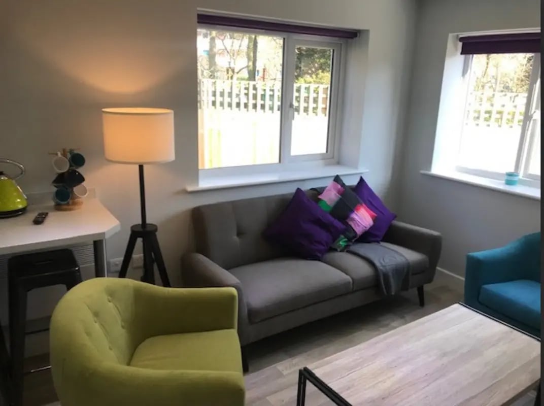 Grey sofa green chair coffee table living room at Varsity Beeston in Nottingham Student Accommodation