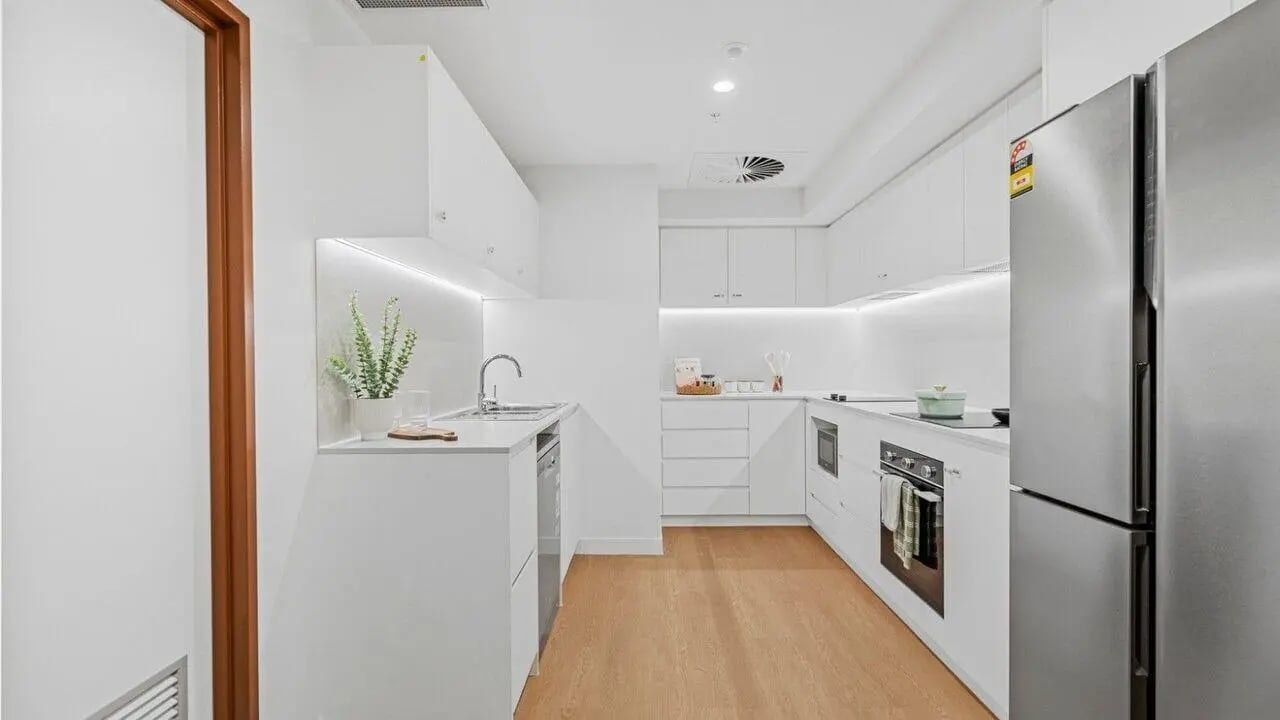 Modern white kitchen with stainless steel fridge kitchen at UniLodge Brisbane City in Brisbane Student Accommodation