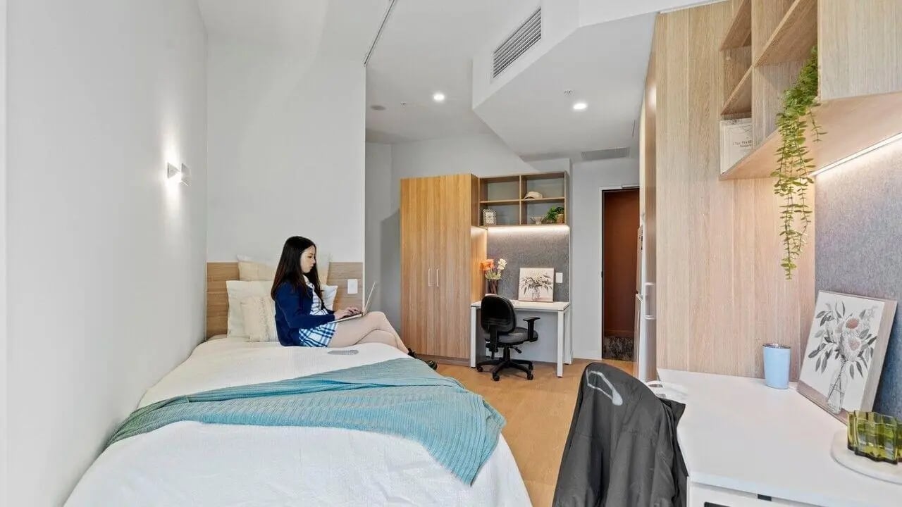 Bed laptop desk wardrobe shelves bedroom study area at UniLodge Brisbane City in Brisbane Student Accommodation