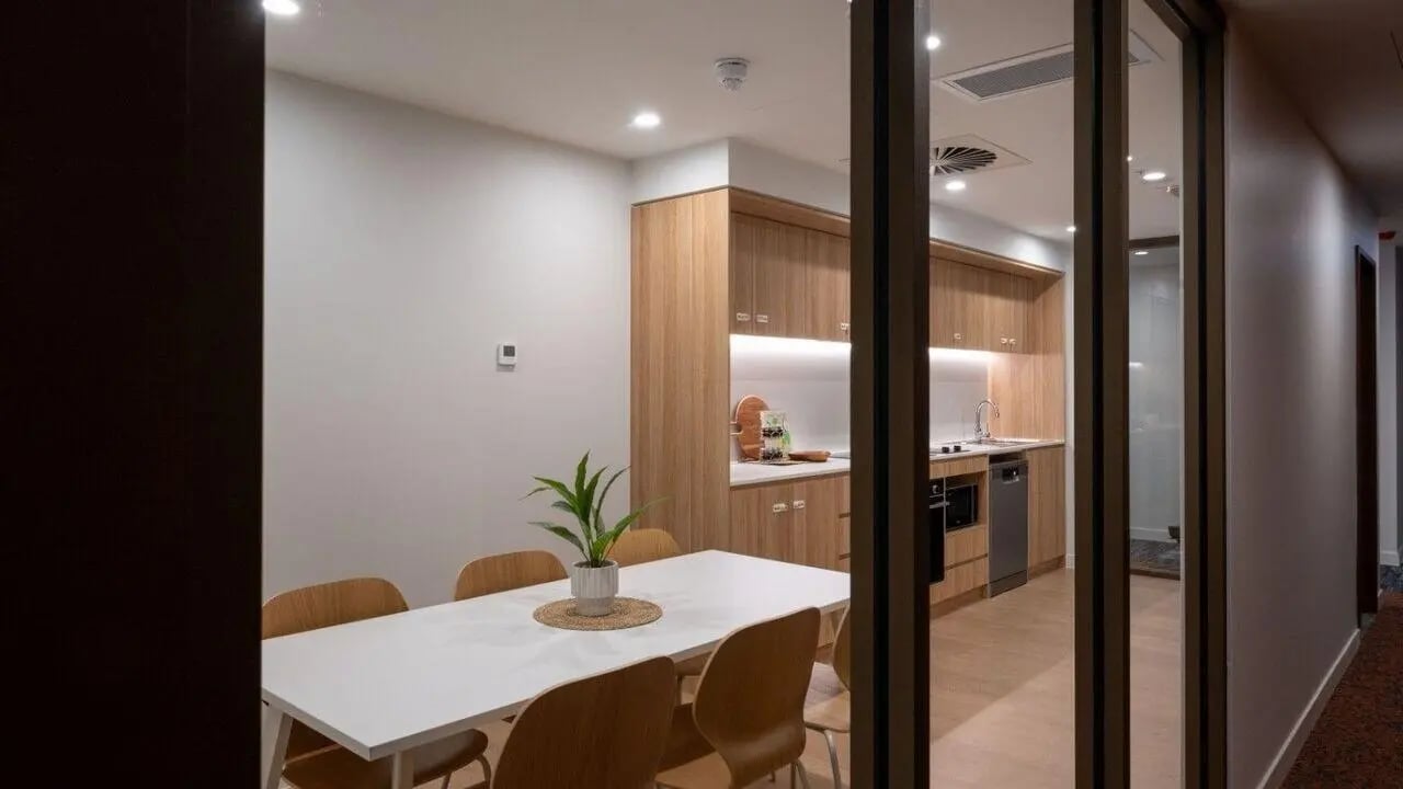 White table wooden chairs modern kitchen area dining room at UniLodge Brisbane City in Brisbane Student Accommodation