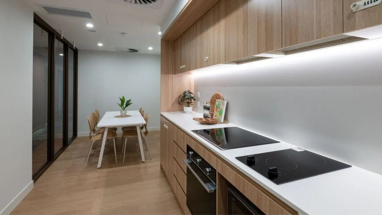 White table chairs plant kitchen with ovens kitchen area at UniLodge Brisbane City in Brisbane Student Accommodation