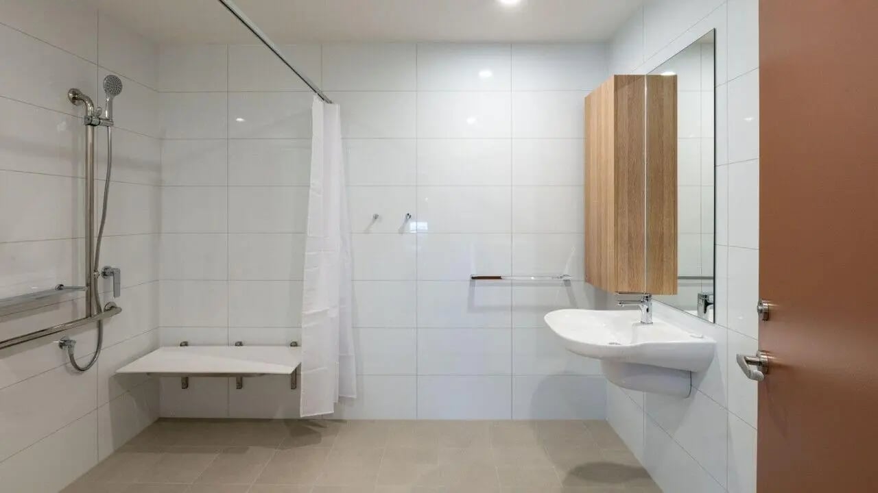 Shower with seat sink and wooden cabinet bathroom at UniLodge Brisbane City in Brisbane Student Accommodation